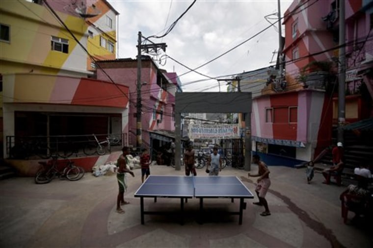 In this photo taken Dec. 17, 2010 residents play table tennis at the Santa Marta slum in Rio de Janeiro, Brazil. In 2008 police stormed Santa Marta to evict the dealers as the community became the pilot in a program to root out gangs and bring government services to slums long abandoned by the state. The program has since been replicated in a dozen slums, all in a bid to make one of the world's more dangerous cities safer before the 2014 World Cup and the 2016 Olympics. (AP Photo/Felipe Dana)
